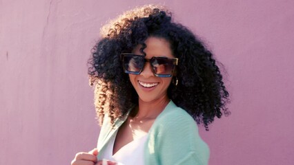 Cool black woman afro, sunglasses and fashion in fun summer style against a pink wall background. Portrait of a happy attractive African female smiling in stylish glasses, curly hair and urban look - Powered by Adobe