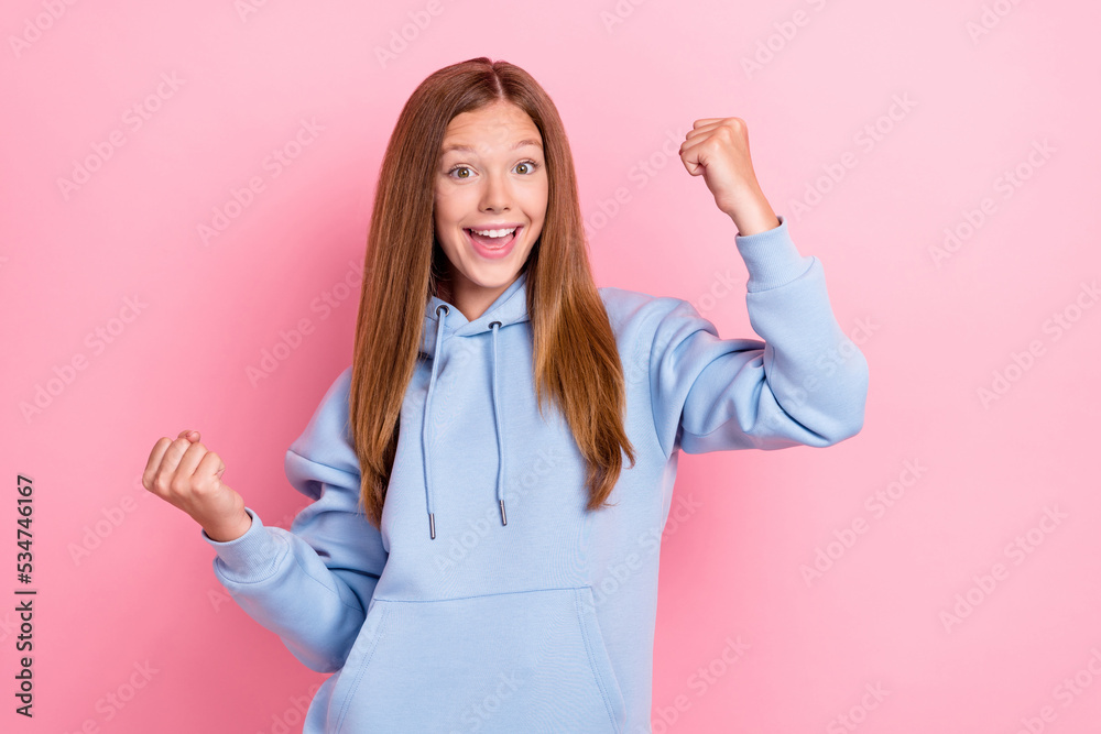 Wall mural Photo of young pretty nice cute little girlish schoolkid wear blue hoodie fists up celebrate excited winner victory yeah isolated on pink color background - Wall murals