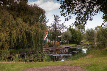 canal de agua con reflejos y cielo azul con casa y jardín en el pueblo De Zaanse Schans en holanda, países bajos