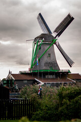 Molino de viento tradicional en pueblo turístico holandés, junto al rio Zaan en países bajos,...