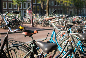 aparcamiento de bicicletas con canal al fondo en ámsterdam, países bajos, holanda