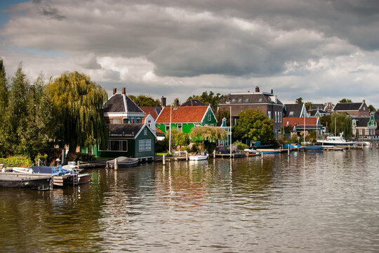 casas de colores bonitas y tradicionales con embarcaderos al borde del mar en Zaandijk, holanda, pa&iacute;ses bajos