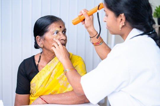 closeup shot of docter checking or obesering patient eye during body checkup at hospital - concept of healthcare, mediacal service and professional occupation.