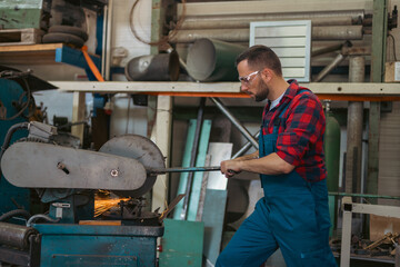 Fototapeta na wymiar man, worker using a sliding compound miter saw with circular blade for cutting metal