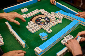 Elderly people playing mahjong, indoor gamble activity at home during spring festival.