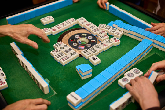 Elderly people playing mahjong, indoor gamble activity at home during spring festival.