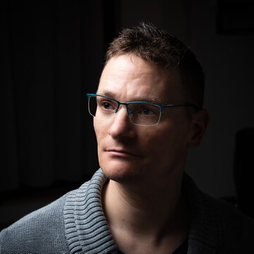 Studio portrait of a 41 year old business man, wearing a gray pull over