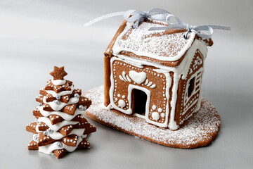 Gingerbread Christmas tree and house on silver background, copy space.
