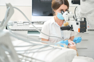 Surgeon dentist treats teeth to a patient
