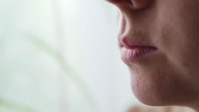 Woman bite zephyr or marshmallow and lick her lips, static close up side view.