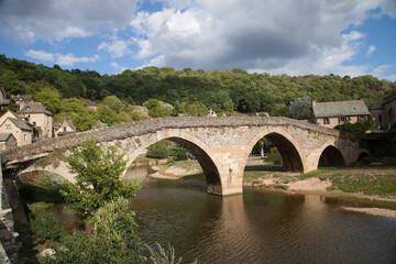 Fototapeta na wymiar Un pont de pierre enjambe la rivière Aveyron au village de Belcastel