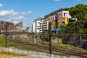 Fototapeta na wymiar Voies ferrées entourées d'immeubles résidentiels au sud de la Gare Saint-Roch de Montpellier