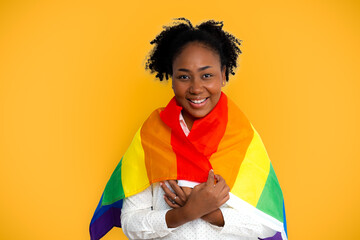 Young african american black curly hair woman with lgbt pride flag. happy smile face on yellow color background