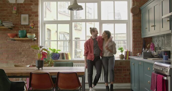 Young Adult Couple Romantic in Kitchen at Home