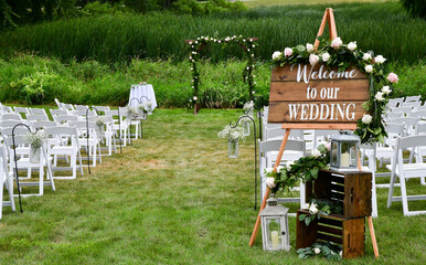 Wedding sign and chairs in the grass