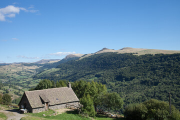 Maison au toit de lauzes face à la chaîne des Puys du Cantal