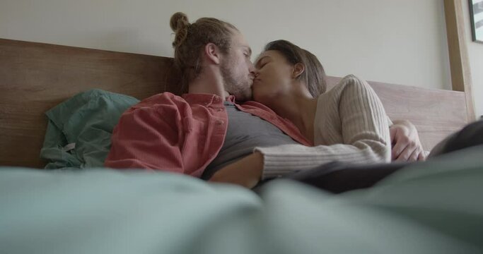 Couple Embracing and Laughing in Bedroom at Home