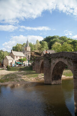 Touristes franchissant un pont sur la rivière Aveyron près du village de Belcastel