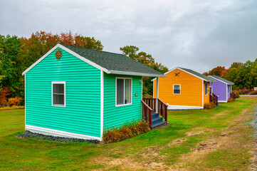 Fototapeta na wymiar Colorful wooden homes in a foliage landscape, autumn season