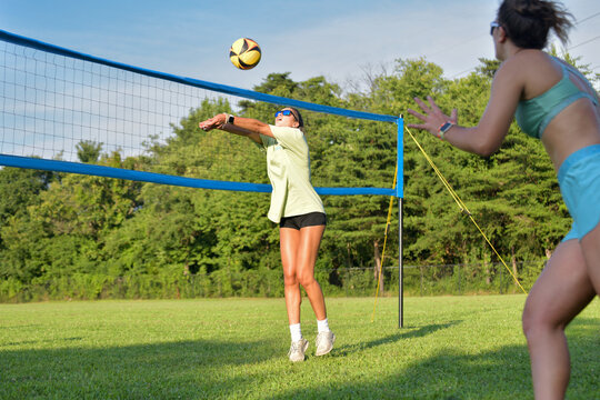Volleyball player setting the ball in a outdoor grass game