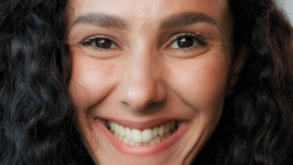 Close up girl face young beautiful arabian hispanic mexican model young woman gorgeous lady with curly hairstyle open eyes positive smiling looking at camera cheerful soft white healthy smile laughing
