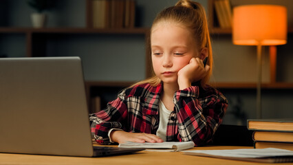Weary sleepy caucasian young child blonde little lazy tired girl studying routine online elementary educational lesson on laptop napping at home feeling boredom chronic burnout fatigue after computer