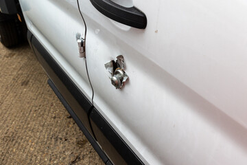 Broken vehicle door lock. Side panel cut with angle grinder.  White van damaged by a thief. Example of rural crime and vehicle crime in the UK. © Nigel Graver