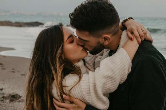 Pareja de enamorados disfrutando del atardecer en la playa