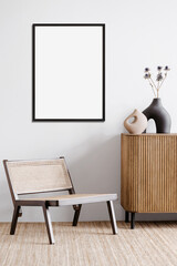 Blank picture frame mockup on a white wall. Portrait orientation. Artwork template mock up in interior design. View of modern boho style interior with chair