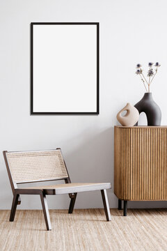 Blank Picture Frame Mockup On A White Wall. Portrait Orientation. Artwork Template Mock Up In Interior Design. View Of Modern Boho Style Interior With Chair