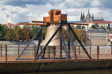 The Commemorative bell #9801 on a pontoon in the Vltava river at Smetanovo nábřeží. Prague.  Prague Castle in behind.