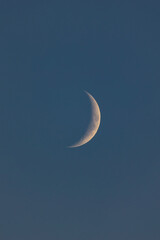 Obraz na płótnie Canvas Waning crescent moon illuminated in a deep blue night sky