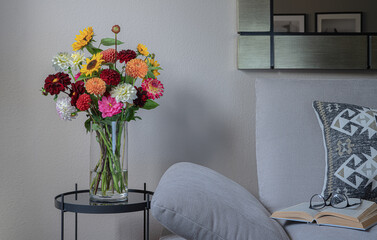 Modern living room interior with coffee table,flowers,sofa with decorative pillows. Cozy home lounge.