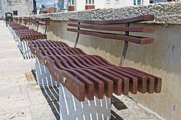 Public benches in Portsmouth, United Kingdom, overlooking the sea, have a wavy pattern to the seats possibly imitating the waves.