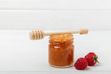 Honey in a glass jar. Raspberry honey jam. Remedy for colds and respiratory diseases. Organic product of a vegetarian diet. copy space. copy space