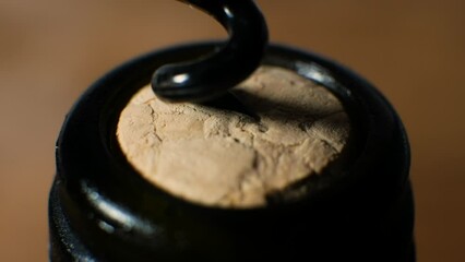 Close-up unscrew the cork in the bottle. Opening a bottle of red wine with a corkscrew macro frame