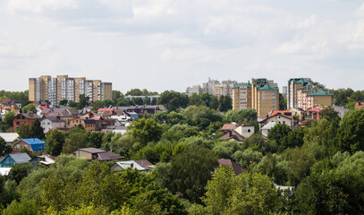 Fototapeta na wymiar Panoramic top view of residential buildings among the lush green foliage of trees in Vladimir russia in the a cloudy summer day and a copy space