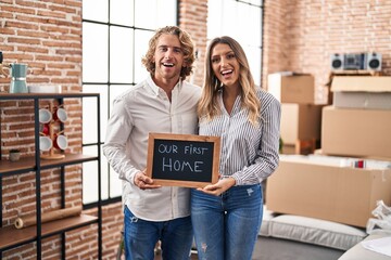 Young couple moving to a new home smiling and laughing hard out loud because funny crazy joke.