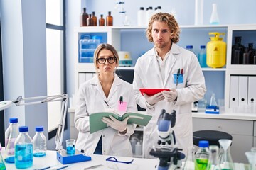 Two people working at scientist laboratory depressed and worry for distress, crying angry and afraid. sad expression.