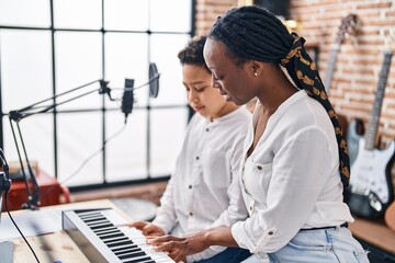 African american mother and son student learning play piano at music studio