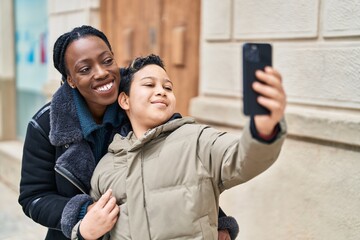 African american mother and son smiling confident make selfie by the smartphone at street