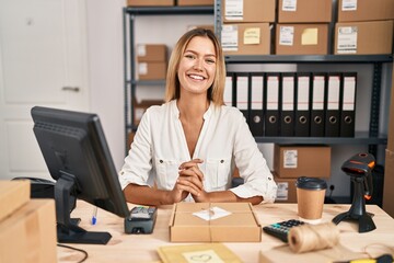 Young blonde woman working at small business ecommerce with a happy and cool smile on face. lucky person.