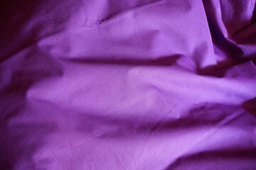 Ausgerolltes lila Bettlaken mit Faltenmuster