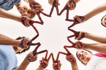 Group of young friends doing victory sign with fingers and hands together.