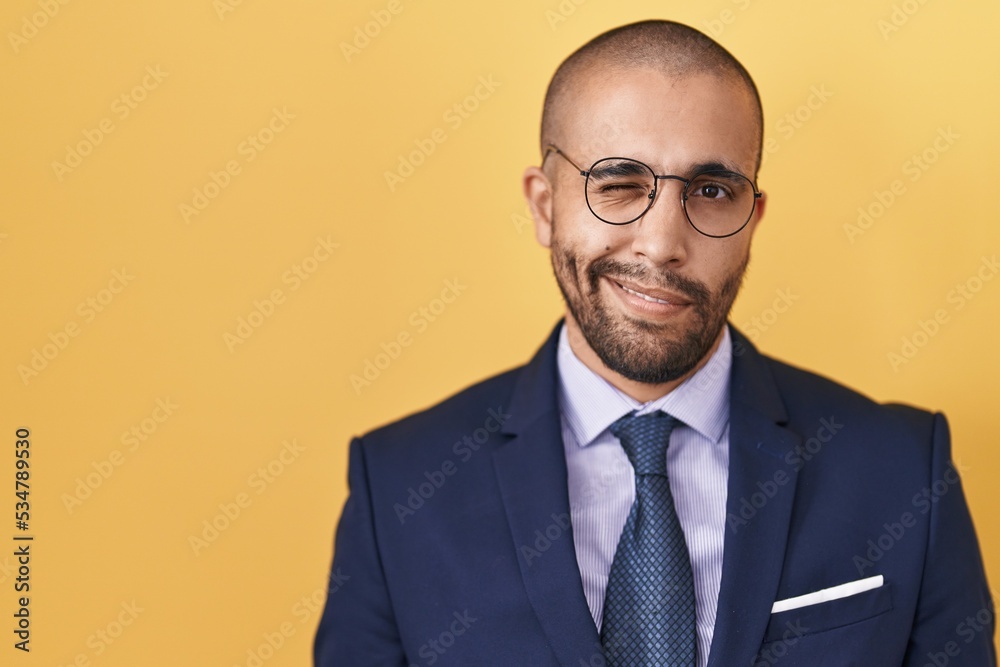 Sticker hispanic man with beard wearing suit and tie winking looking at the camera with sexy expression, che