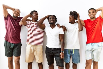 Obraz premium Young african group of friends standing together over isolated background smiling confident touching hair with hand up gesture, posing attractive and fashionable