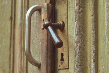 Old vintage door handle, green wooden background                   