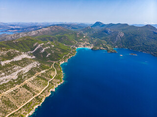 aerial view of the peljesac peninsula in croatia; paradise beaches with turquoise water and rocky coastline; mighty mountains over the mediterranean sea; peljesac bridge; croatian adriatic coastline