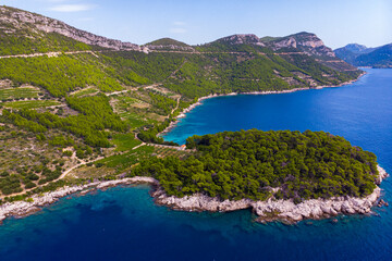Obraz premium aerial view of a wonderful Mediterranean bay on the peljesac peninsula; paradise beach with turquoise water and rocky coastline with mighty mountains in the background; trstenik in croatia