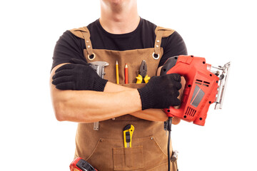 Carpenter in workers apron holding electric jig saw on white background